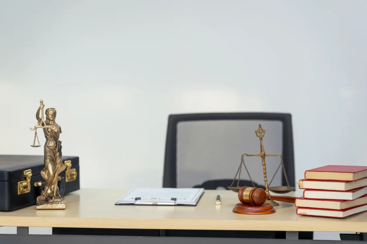 A legal office desk with scales of justice, a gavel and law books