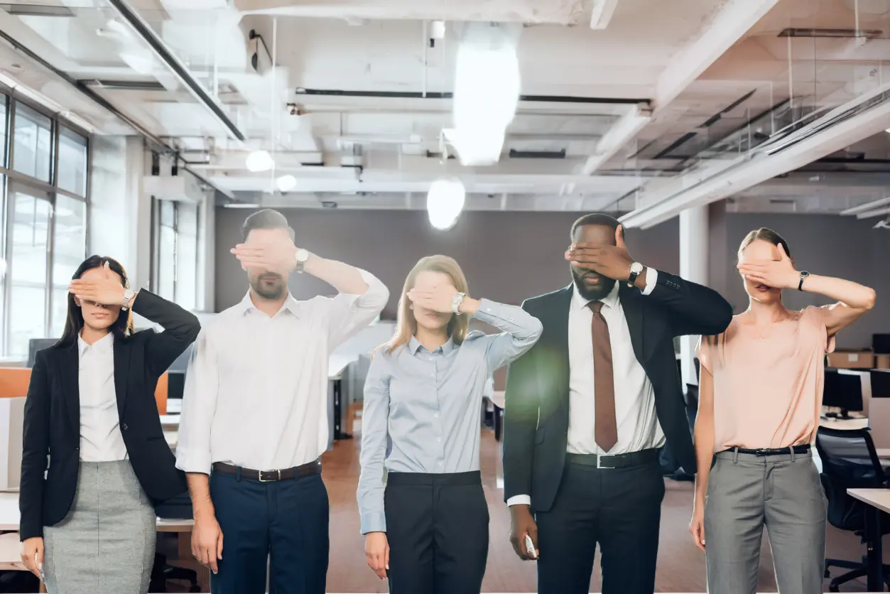 Five colleagues standing in an office with their eyes covered