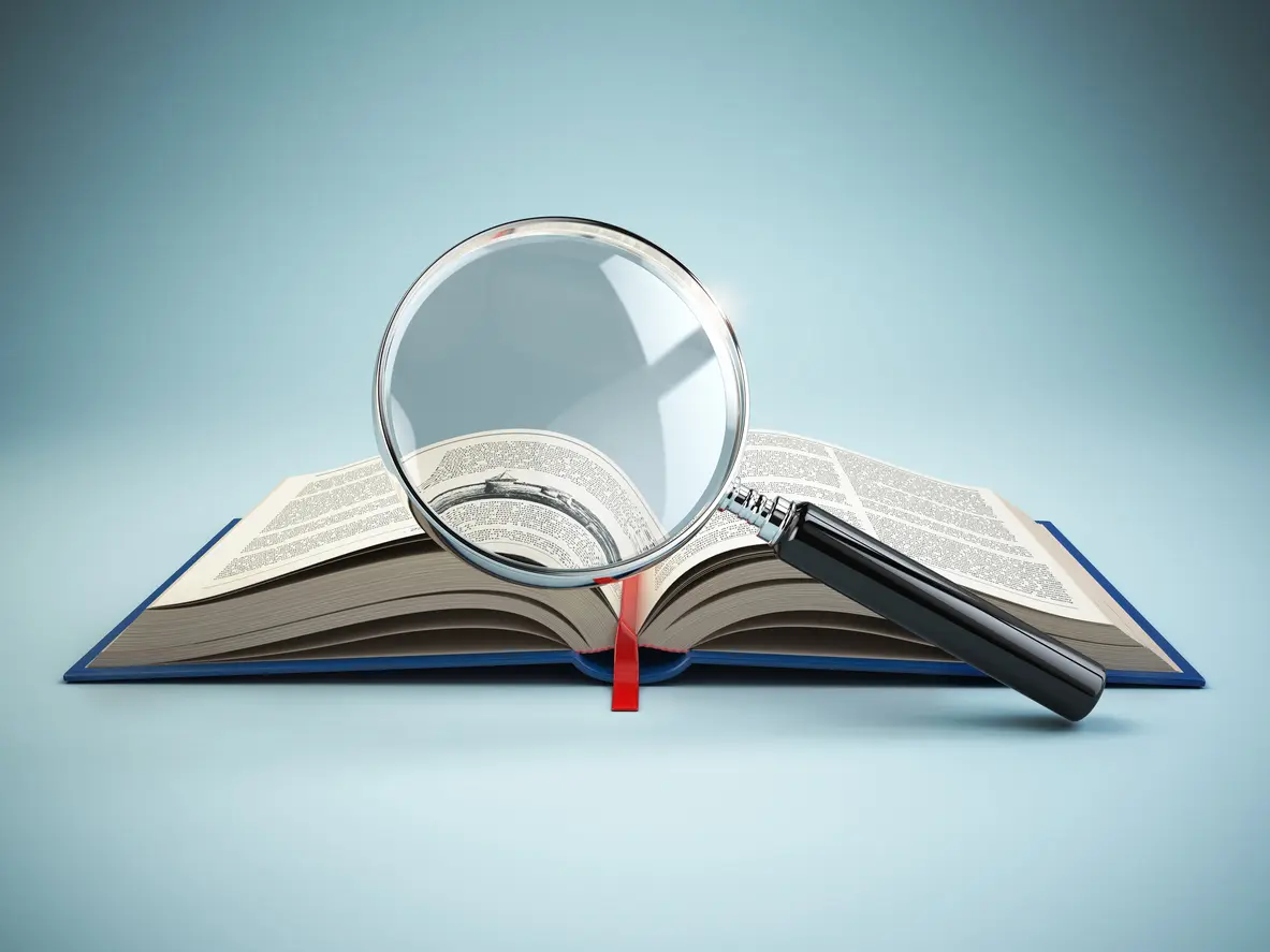 A magnifying glass resting over an open book